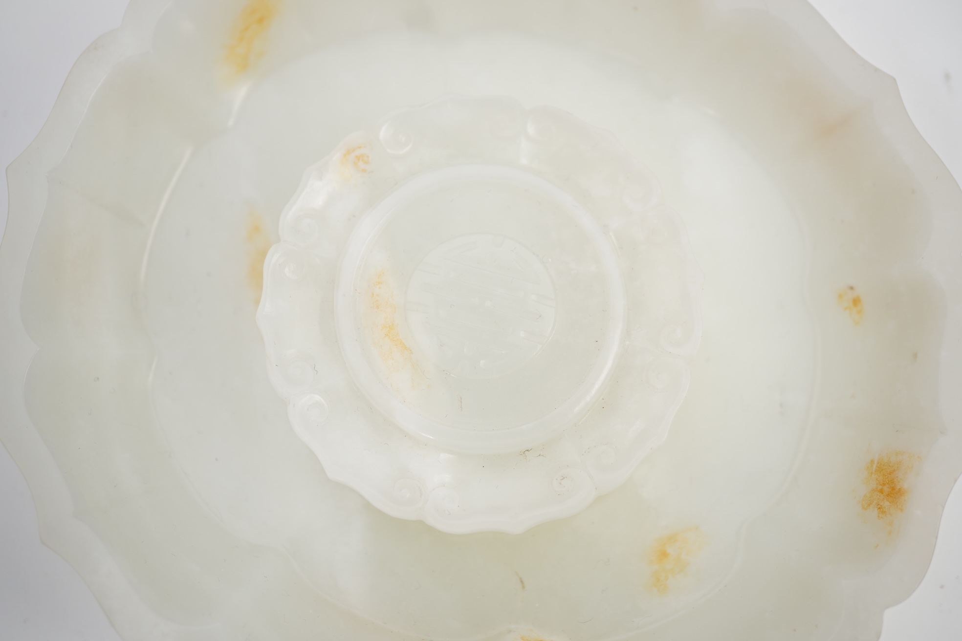 A Chinese white and russet jade petal lobed cup stand